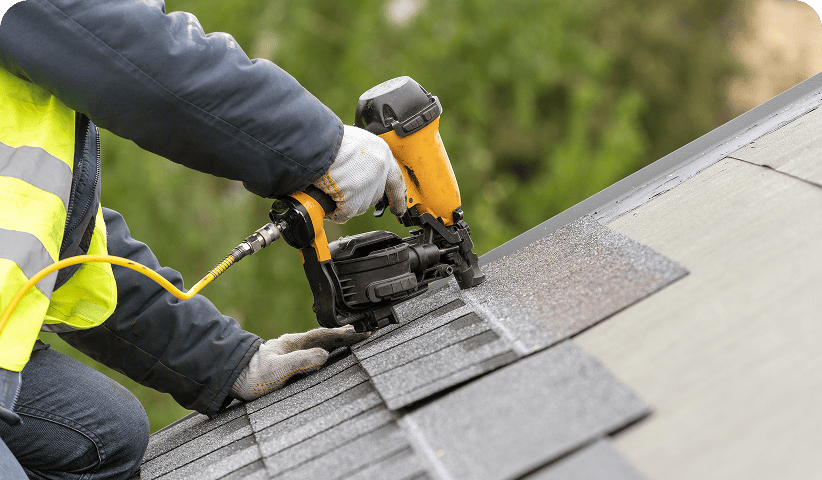 Roofing contractor securing shingles with tools