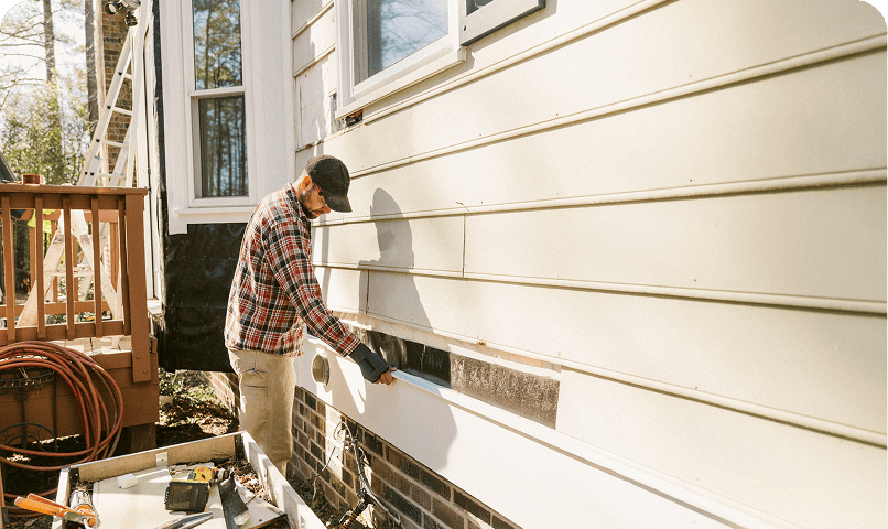 Man working on house siding repair