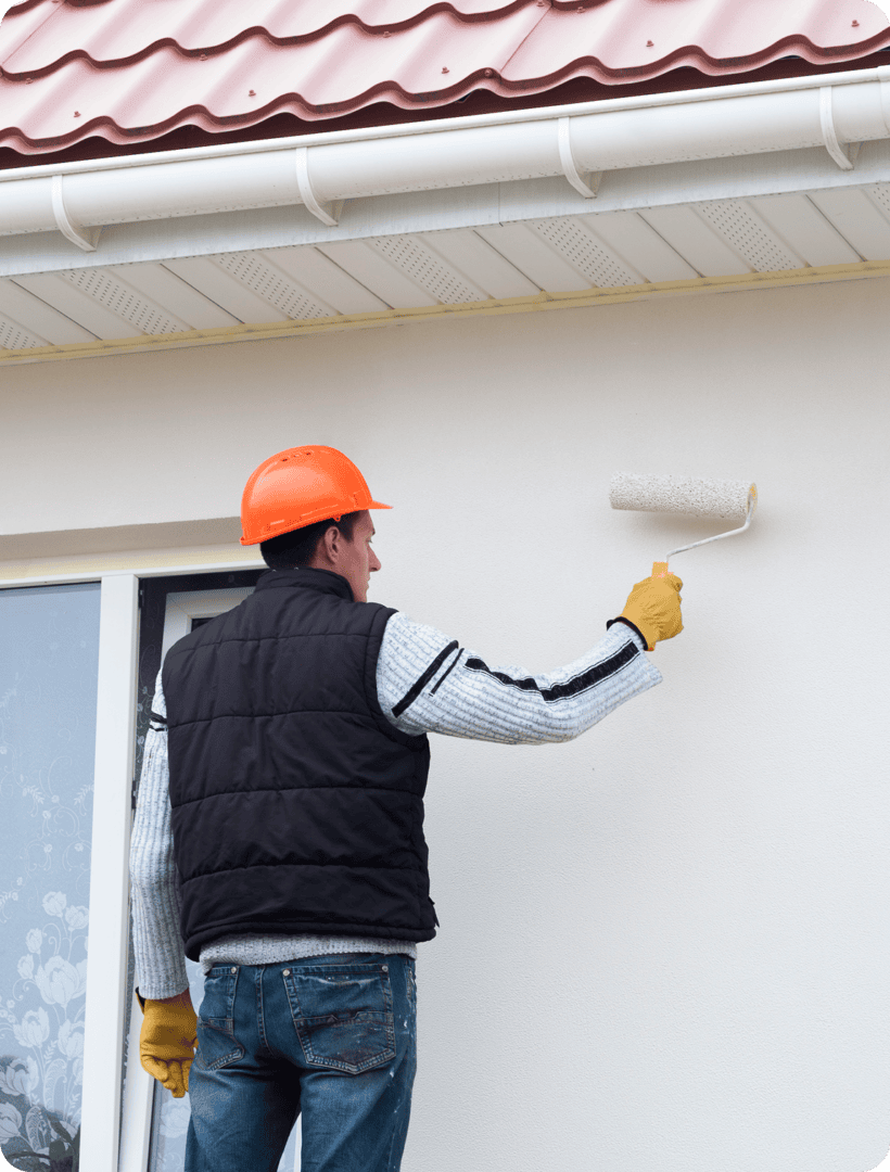 Man painting house wall with roller.