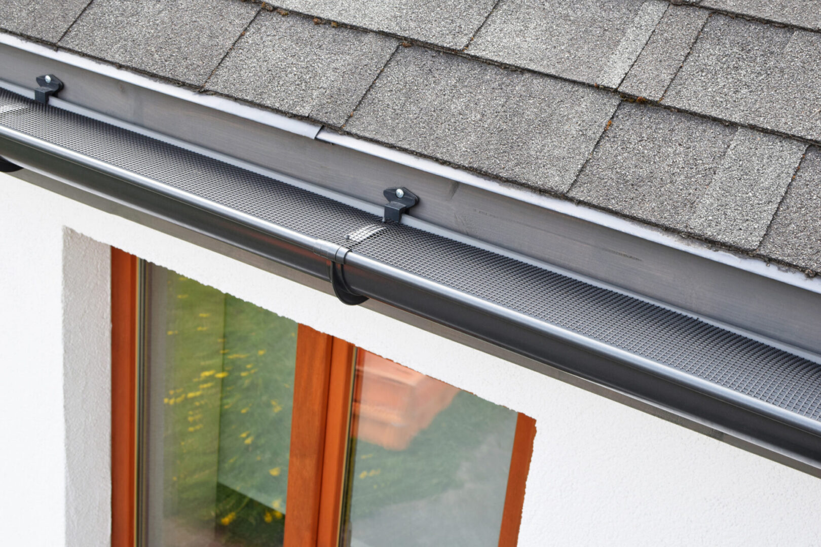 Modern roof gutter with mesh cover
